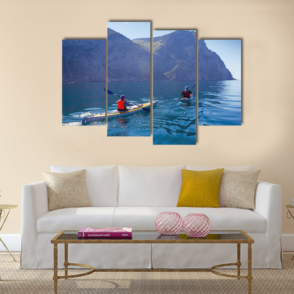 People kayaking in the sea near the mountains multi panel canvas wall art