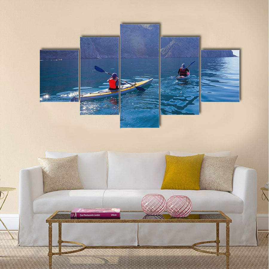 People kayaking in the sea near the mountains multi panel canvas wall art