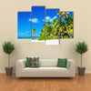 Amazing tropical beach with palm tree entering the ocean against Azur Ocean, gold sand and blue sky Multi panel canvas wall art