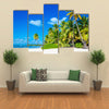 Amazing tropical beach with palm tree entering the ocean against Azur Ocean, gold sand and blue sky Multi panel canvas wall art