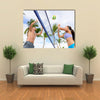 Woman and man having fun in volley ball game in summer Multi panel canvas wall art