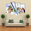 Woman and man having fun in volley ball game in summer Multi panel canvas wall art