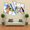 Woman and man having fun in volley ball game in summer Multi panel canvas wall art