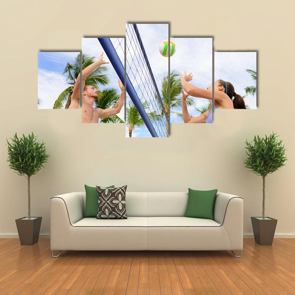Woman and man having fun in volley ball game in summer Multi panel canvas wall art