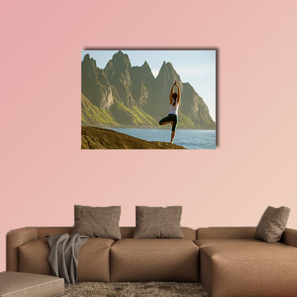Young woman is practicing yoga between mountains in Norway multi panel canvas wall art