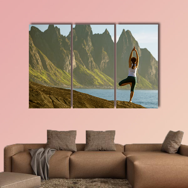 Young woman is practicing yoga between mountains in Norway multi panel canvas wall art