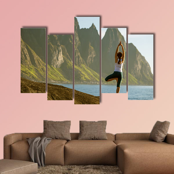 Young woman is practicing yoga between mountains in Norway multi panel canvas wall art