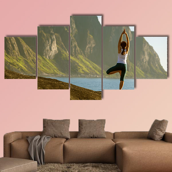 Young woman is practicing yoga between mountains in Norway multi panel canvas wall art