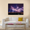 Lightning storm over city in purple light Multi Panel Canvas Wall Art