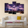 Lightning storm over city in purple light Multi Panel Canvas Wall Art