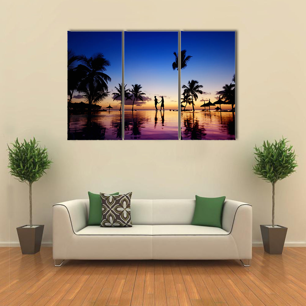 Silhouettes of young couple at scenic sunset on tropical beach multi panel canvas wall art