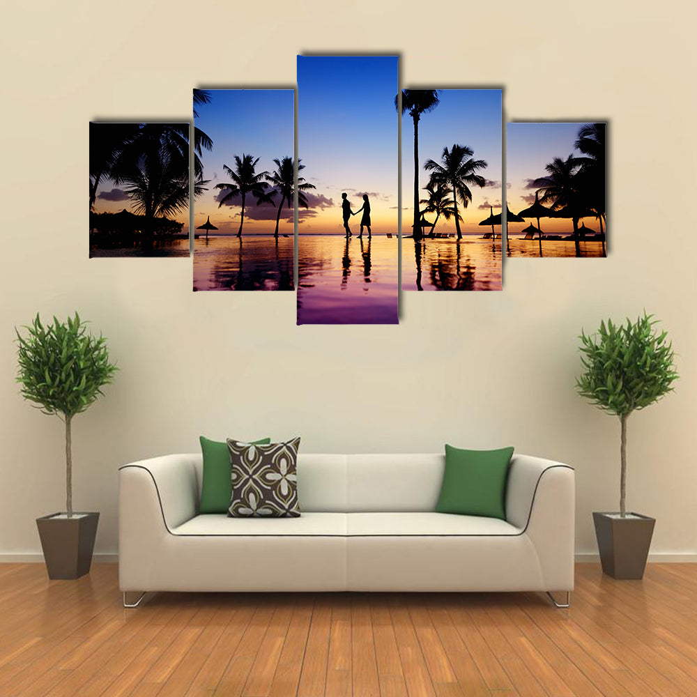Silhouettes of young couple at scenic sunset on tropical beach multi panel canvas wall art