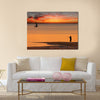 Beach sunset scene in Mozambique with fisherman and small sailboat Multi panel canvas wall art