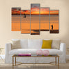 Beach sunset scene in Mozambique with fisherman and small sailboat Multi panel canvas wall art