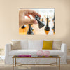 Closeup photo of male hand holding black horse chess piece multi panel canvas wall art