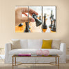 Closeup photo of male hand holding black horse chess piece multi panel canvas wall art