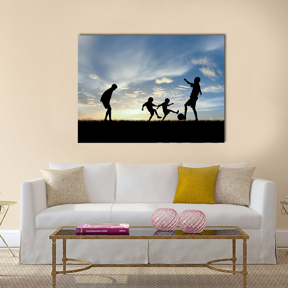 Silhouette boys playing football at sunset Multi panel canvas wall art
