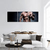 Handsome young man in shorts, doing exercises for biceps Panoramic Canvas Wall Art