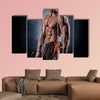 Young handsome sporty man doing exercise with dumbbells Multi panel canvas wall art