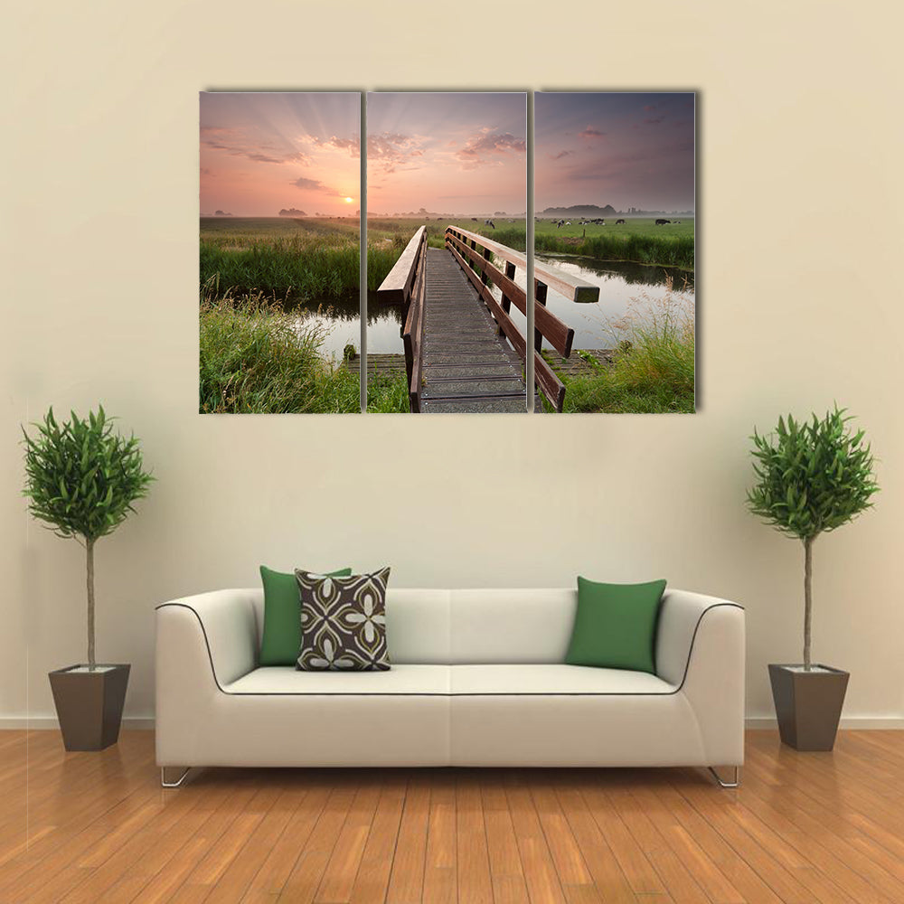 beautiful sunrise over bike bridge in farmland, Netherlands multi panel canvas wall art