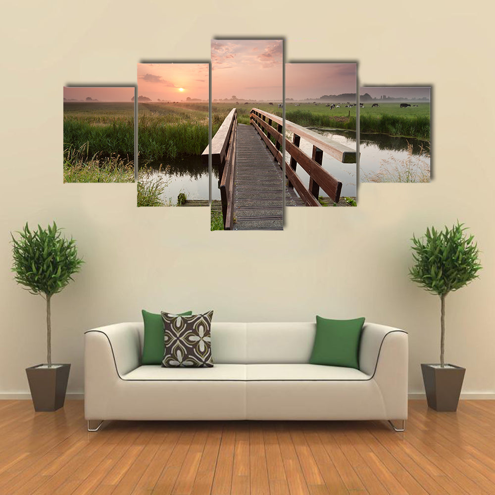 beautiful sunrise over bike bridge in farmland, Netherlands multi panel canvas wall art