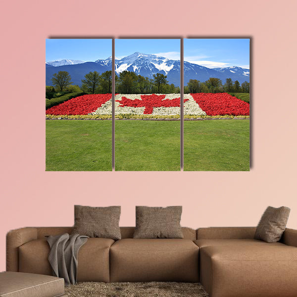 Canada flag done in red and white begonia flower against a backdrop of the rocky mountains Multi panel canvas wall art