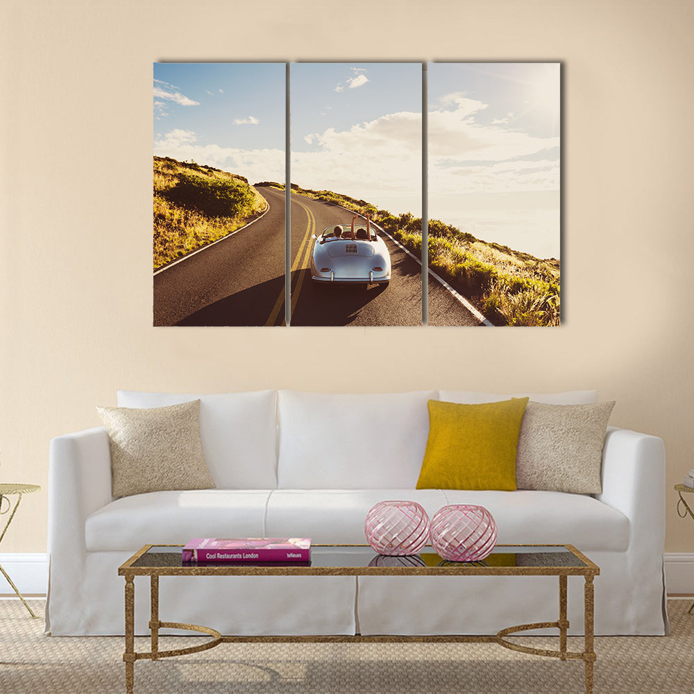 Happy Couple Driving on Country Road in Classic Vintage Sports Car Multi panel canvas wall art