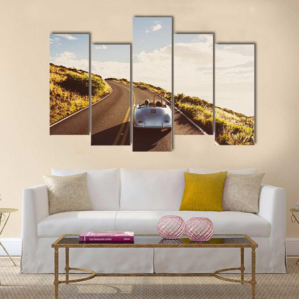 Happy Couple Driving on Country Road in Classic Vintage Sports Car Multi panel canvas wall art