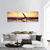 Silhouette of woman practicing yoga on beach at sunset Panoramic Canvas Wall Art