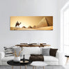 Bedouin on camel near pyramids in desert panoramic canvas wall art