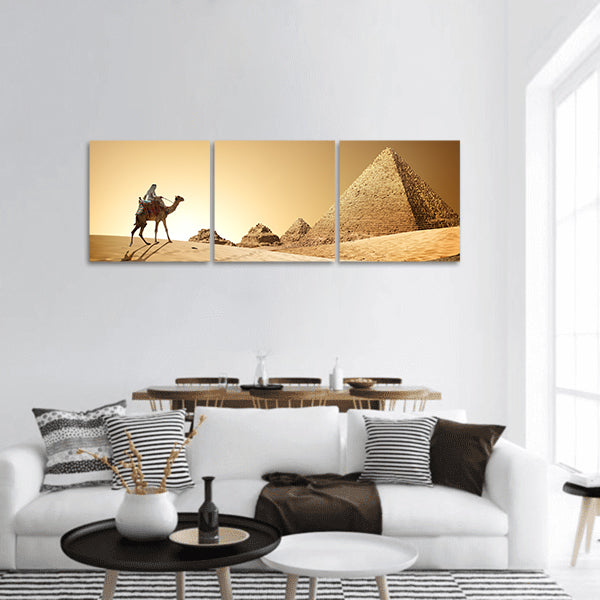 Bedouin on camel near pyramids in desert panoramic canvas wall art