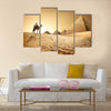 Bedouin on camel near pyramids in desert  Multi panel canvas wall art