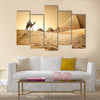 Bedouin on camel near pyramids in desert  Multi panel canvas wall art