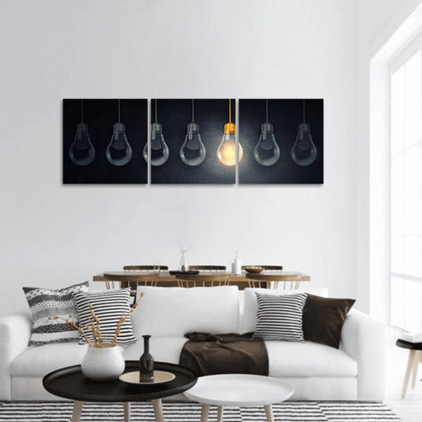 Light bulbs on dark background with one glowing panoramic canvas wall art