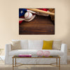 An old, antique American flag with vintage baseball equipment on a wooden bench Multi Panel Canvas Art