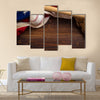 An old, antique American flag with vintage baseball equipment on a wooden bench Multi Panel Canvas Art