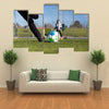 Close-up of young soccer player taking a penalty kick against a young blurred boy Multi panel canvas wall art