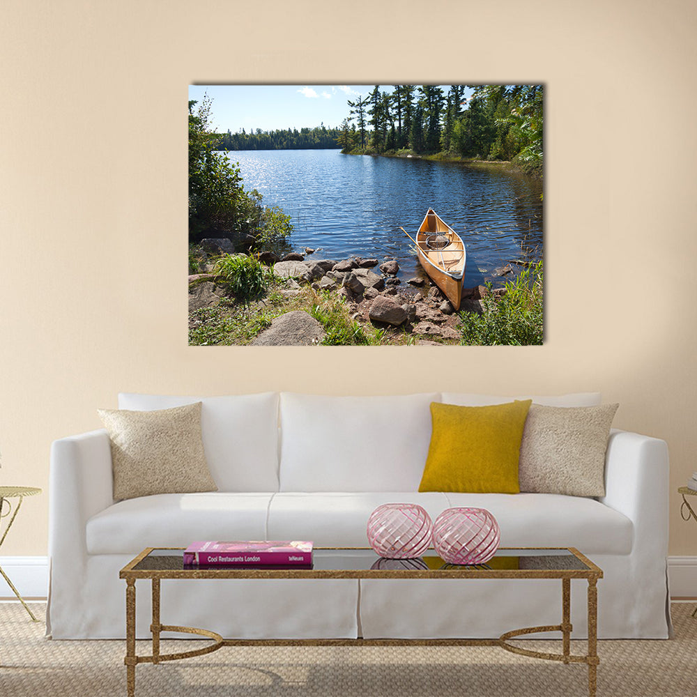 A yellow fisherman's canoe on a rocky shore of a northern Minnesota lake multi panel canvas wall art