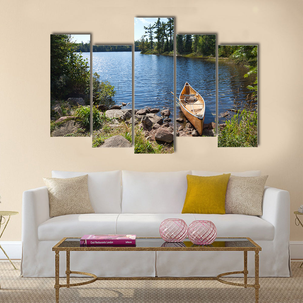 A yellow fisherman's canoe on a rocky shore of a northern Minnesota lake multi panel canvas wall art