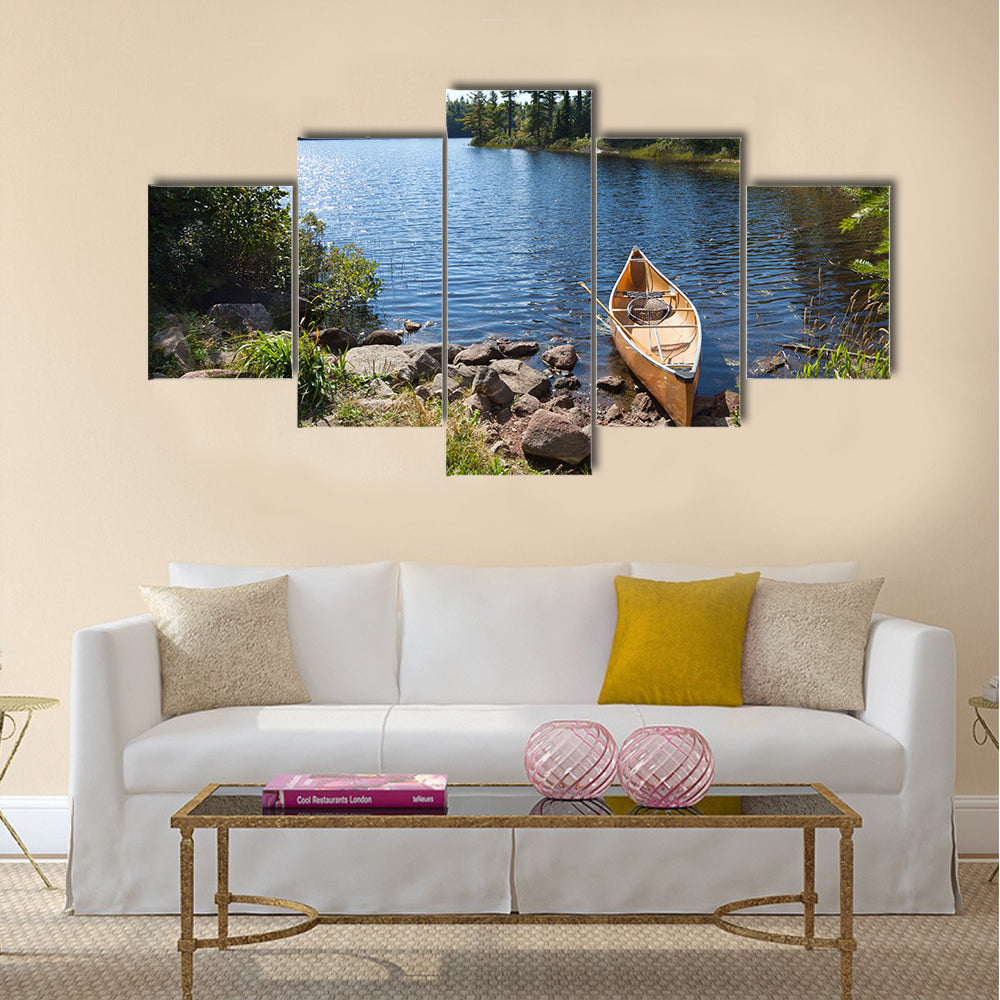 A yellow fisherman's canoe on a rocky shore of a northern Minnesota lake multi panel canvas wall art