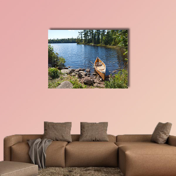 A yellow fisherman's canoe on a rocky shore of multi panel canvas wall art