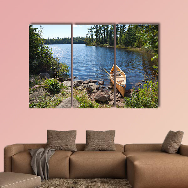 A yellow fisherman's canoe on a rocky shore of multi panel canvas wall art