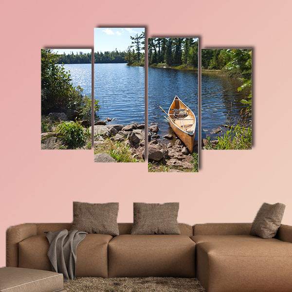 A yellow fisherman's canoe on a rocky shore of multi panel canvas wall art