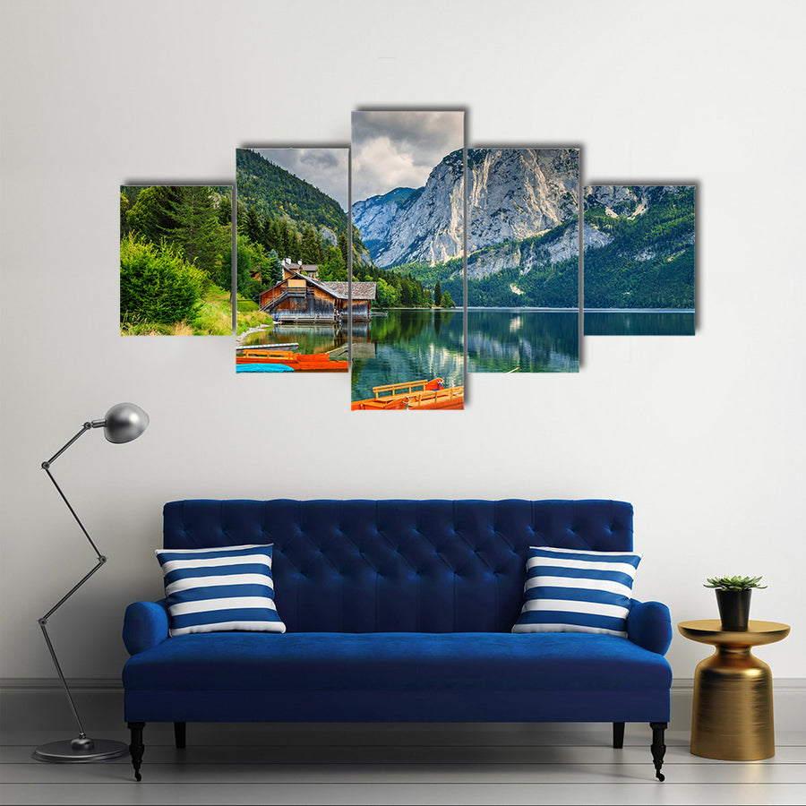 Wooden boat dock with traditional boats and high rocky mountains multi panel canvas wall art