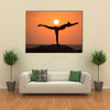 Warrior pose from yoga by woman silhouette on sunset Multi panel canvas wall art