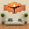 Warrior pose from yoga by woman silhouette on sunset Multi panel canvas wall art