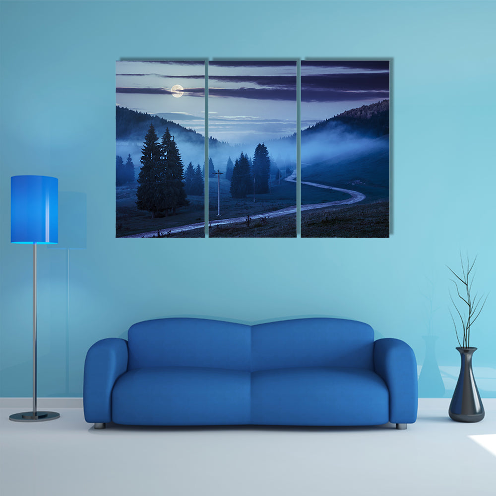 The Road On Through The Meadow Near Few Fir Trees And Forest in foggy mountains Multi Panel Canvas Wall Art