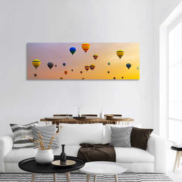 Hot air balloons landing in a mountain panoramic canvas wall art