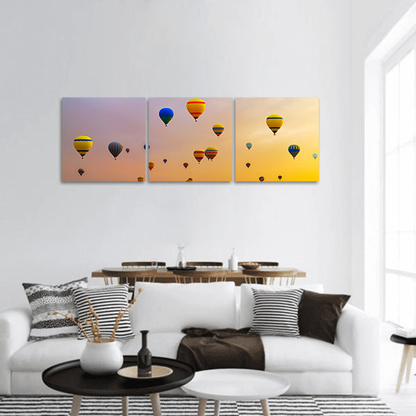 Hot air balloons landing in a mountain panoramic canvas wall art