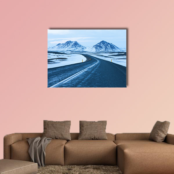 The road at twilight through the snow capped mountains canvas wall art